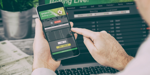 Person holding a phone with betting app open